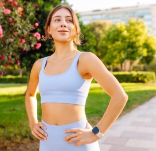 A,Woman,In,Workout,Clothes,Stretches,At,Sunset.,An,Athlete